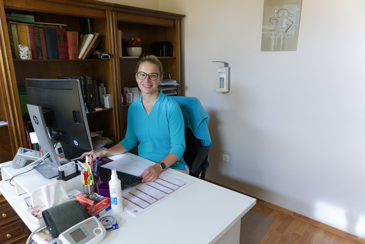 Frau Dr. Rückert in ihrem Behandlunsgzimmer am Schreibtisch.